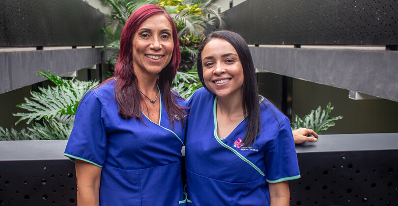 Picture of Estela Araya and a nurse, representing the medical care offered by the Costa Rica Medical Center Inn, San Jose, Costa Rica.  The picture shows both women standing beside each other, wearing blue uniforms, and smiling at the camera.