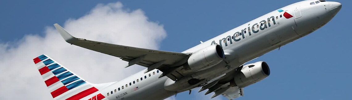 Picture of an American Airlines airplane taking off and bringing frontline heroes to Costa Rica for plastic surgery with Frontline Plastic Surgery.  The airplane has American’s new colors and the sky is blue with a single white cloud in the background.